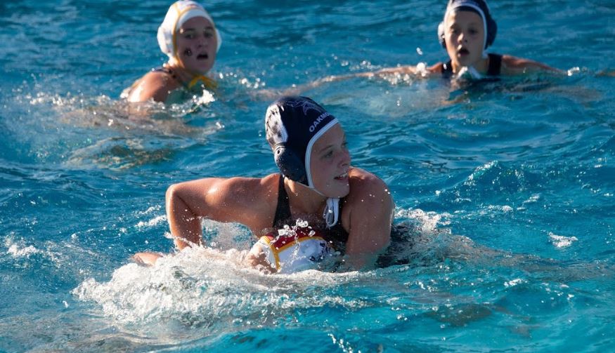 Sophomore Gracie McGrane fights for an opportunity to score by dragging the goalie underwater to give her teammates an opening.