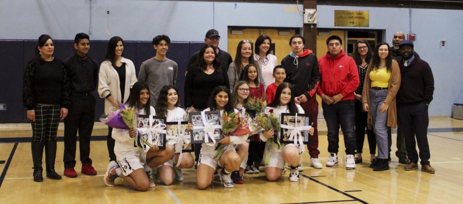 The varsity girls' basketball seniors line up for a final photo with their friends and families (from left to right): Preet Gill, Sophia Piepmeier, Jada Holmes, Maddison Hasegowa, and Kiona Prout