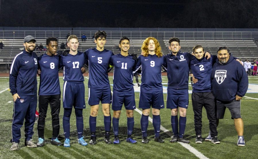 Senior boy's soccer players line up for one last picture with their coaches (from left to right): coach Tom Sinner, Njabulo Mkhize. Jake Neiman, Ben Gonzalez, Christian Barajas, Noah Collins, Javi Gonzalez, Pete Gonzalez, and coach Pete Gonzalez.