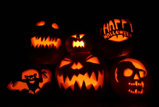 Carved pumpkins set outside of houses as decorations for Halloween.

