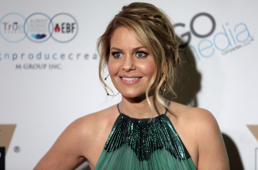Actress Candace Cameron posing at a red carpet event.
