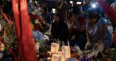 Grieving family and friends at a memorial for the Allen shooting victims.
