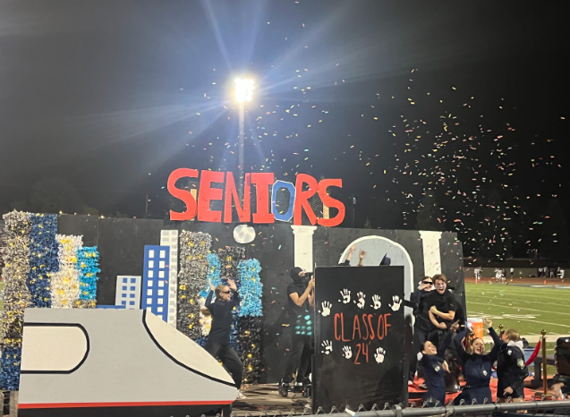 The seniors in spy costumes celebrate after successfully stealing the graduation cap. 
