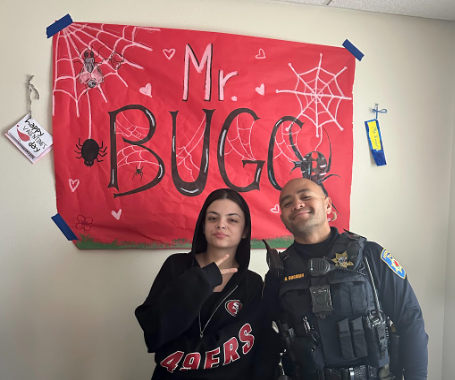 Junior Brooke Waters and Officer Bugarin pose in his office
