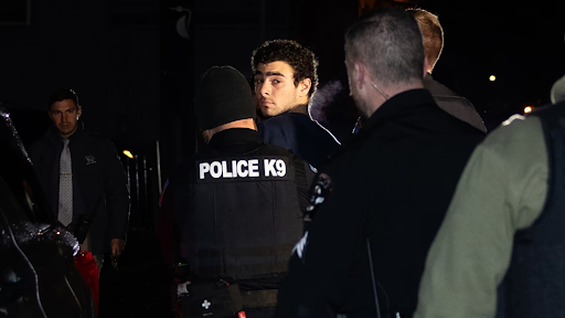 Luigi Mangione being walked into arraignment by PA police. PC: Rachel Wisniewski/New York Times
