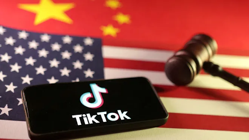 TikTok logo before the American and Chinese flags with a gavel. PC: USA Today
