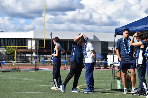 Coach Nugent gives senior Sam Patterson his ribbon lei, marking the end of his time with the Oakmont Track and Field team. 